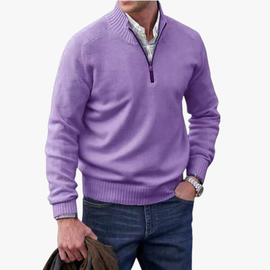 Man wearing a purple sweater with a quarter zip, white shirt, and blue jeans on a white background.