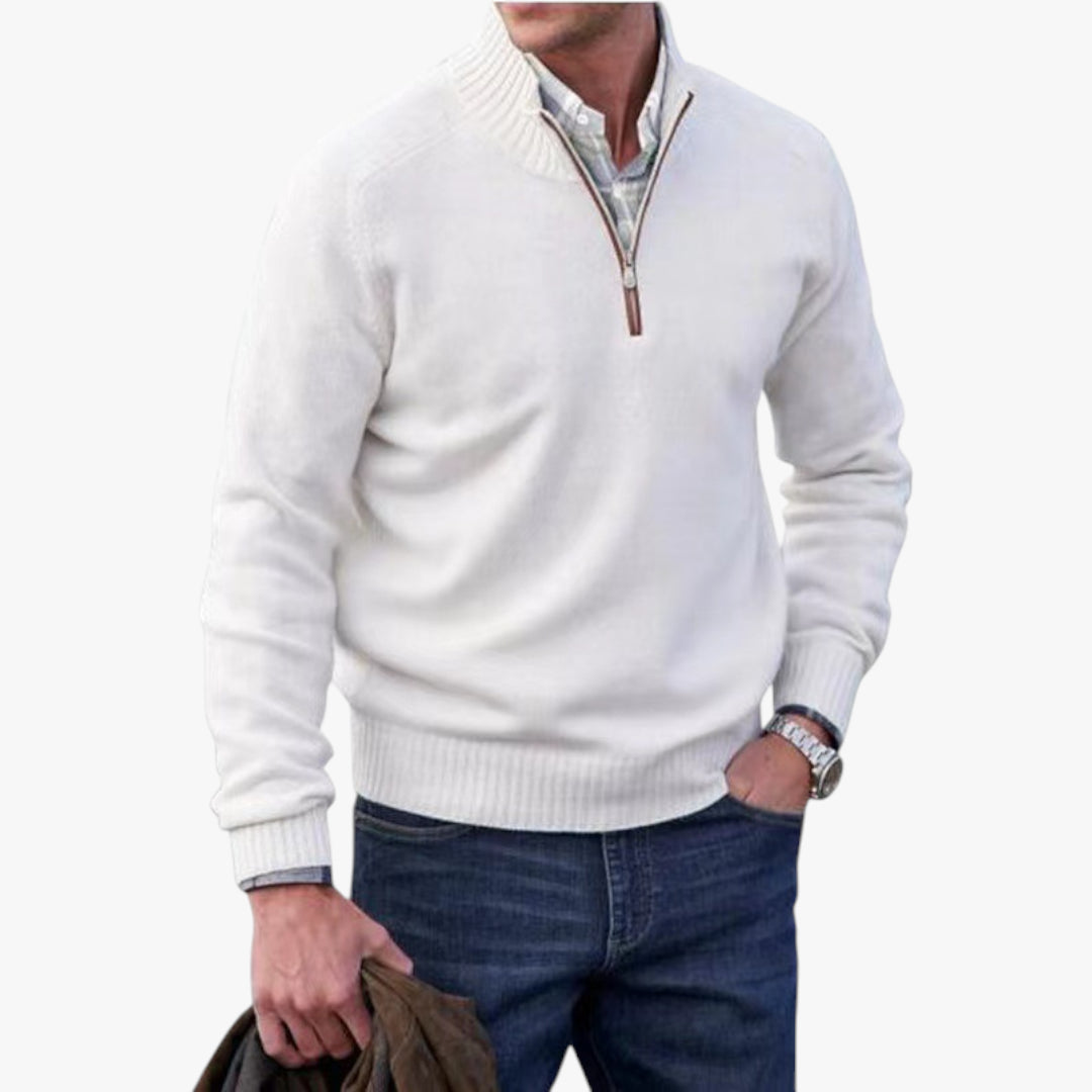 Man wearing a white sweater with a zipper and blue jeans on a white background