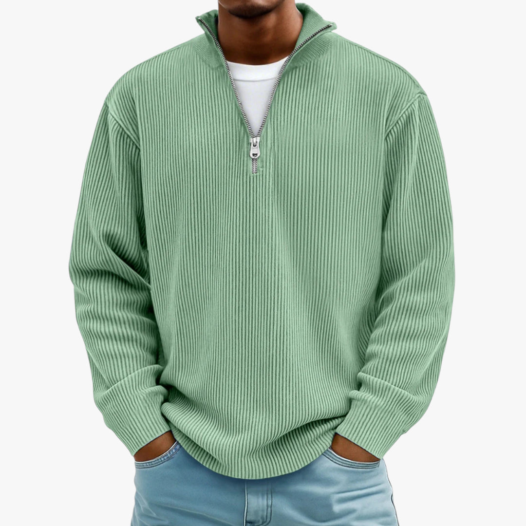 Person wearing a green ribbed sweater with a quarter zip on a white background