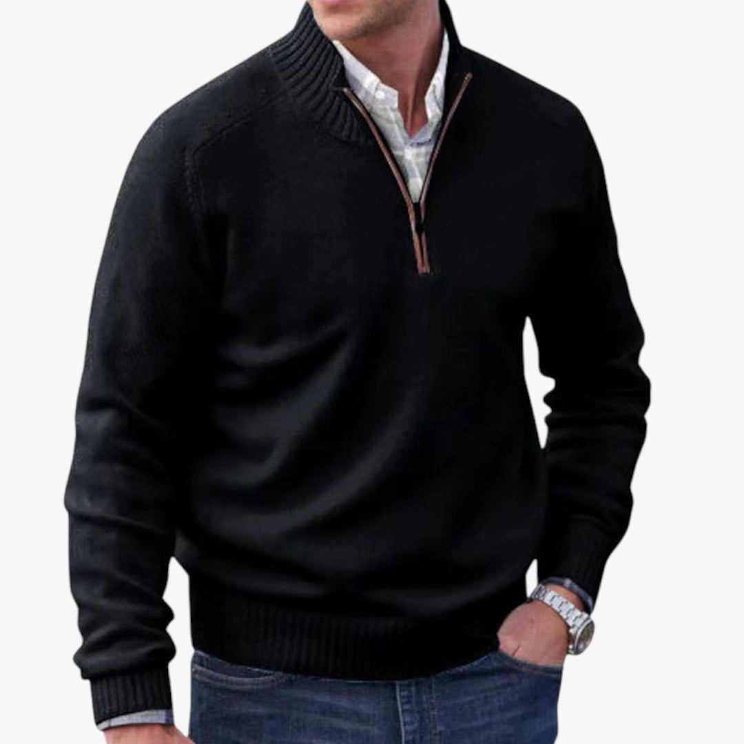 Man wearing a black quarter-zip sweater over a white shirt on a white background