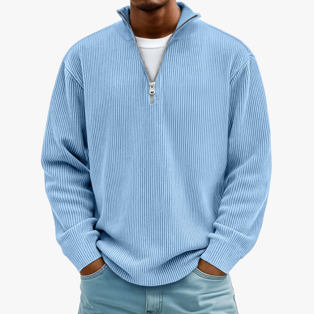 Person wearing a light blue ribbed sweater with a quarter zip on a white background