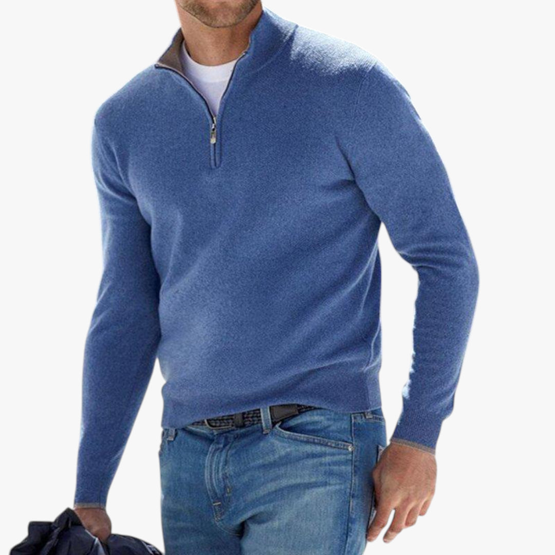 Man wearing a blue quarter-zip sweater and jeans on a white background
