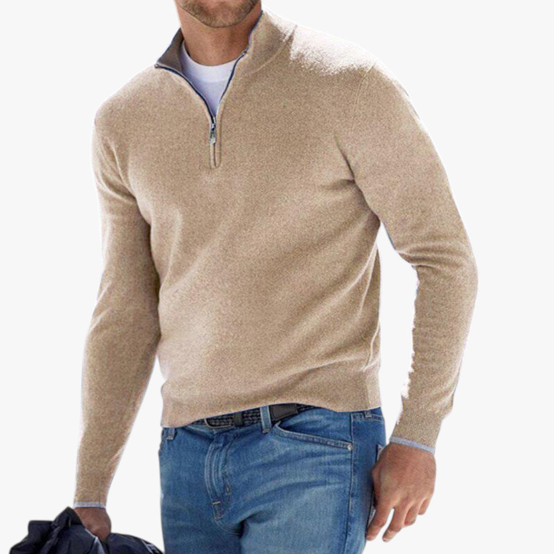 Man wearing a beige sweater and blue jeans on a white background