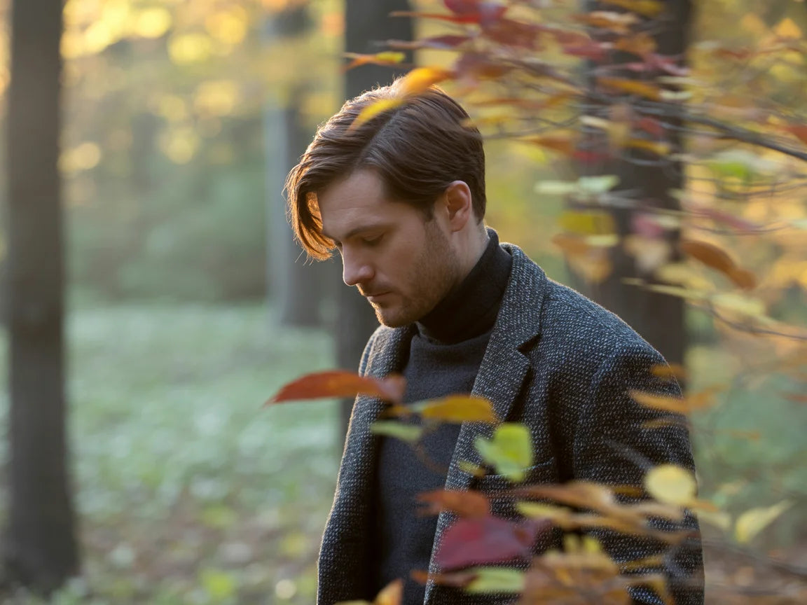 Man standing in a forest with autumn leaves